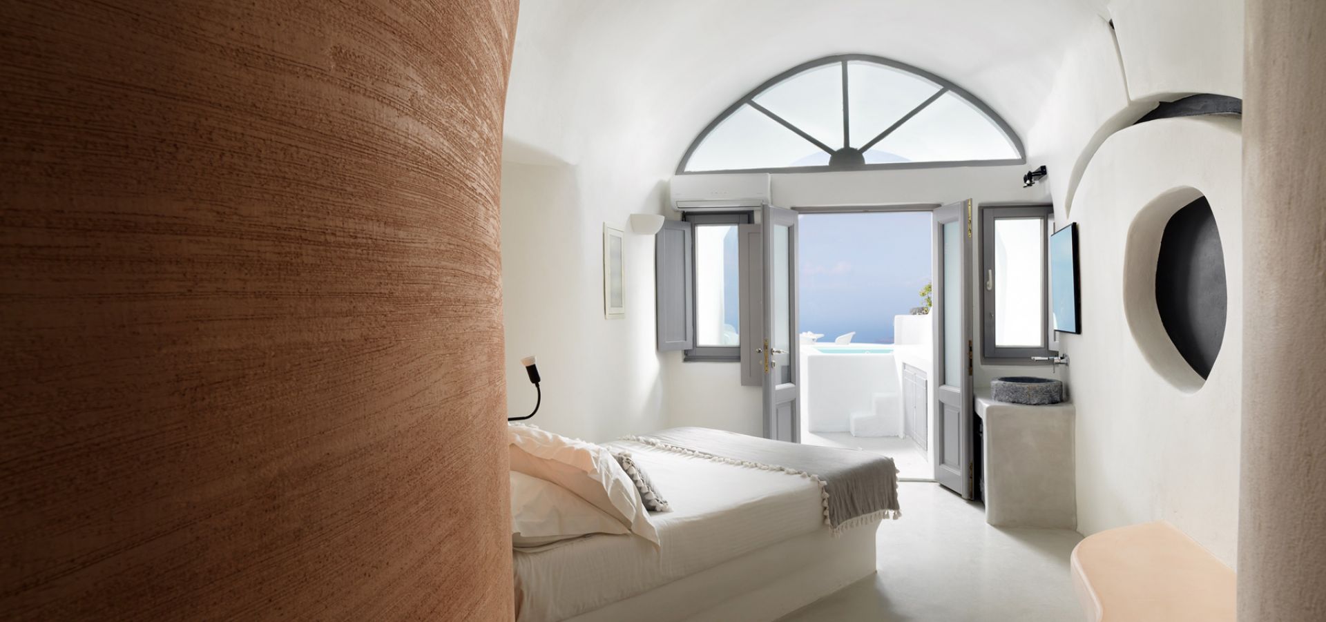 Villa Tholos, con piscina interior, jacuzzi exterior y vistas a la caldera